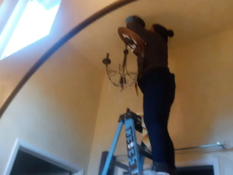 Electrician installing a chandelier in a Tanque Verde residence